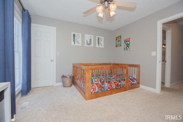 bedroom with light colored carpet, ceiling fan, and baseboards