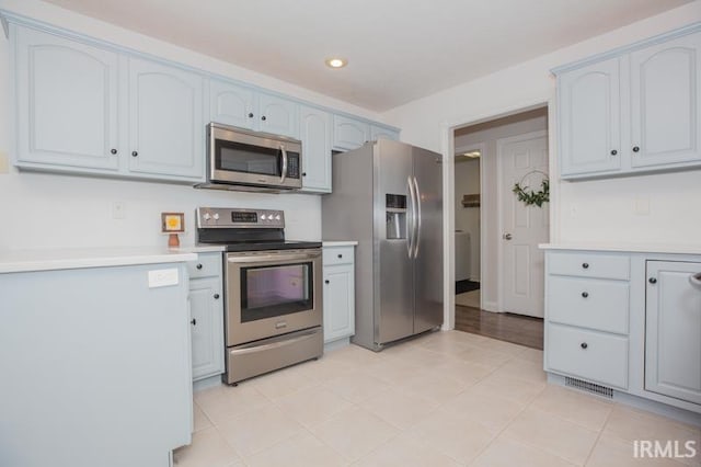 kitchen with stainless steel appliances, light countertops, and recessed lighting