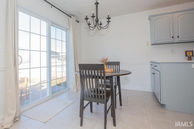 dining space with a healthy amount of sunlight, light tile patterned floors, and a notable chandelier