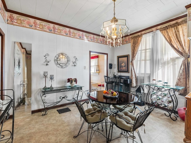 dining space featuring a notable chandelier, ornamental molding, and a healthy amount of sunlight