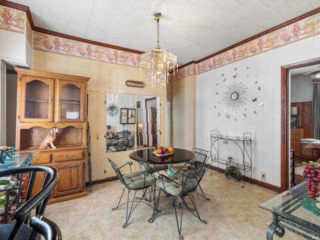 dining area featuring a notable chandelier, baseboards, and crown molding