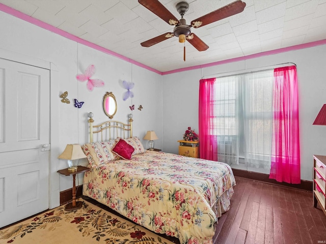 bedroom featuring ceiling fan, baseboards, and dark wood-type flooring