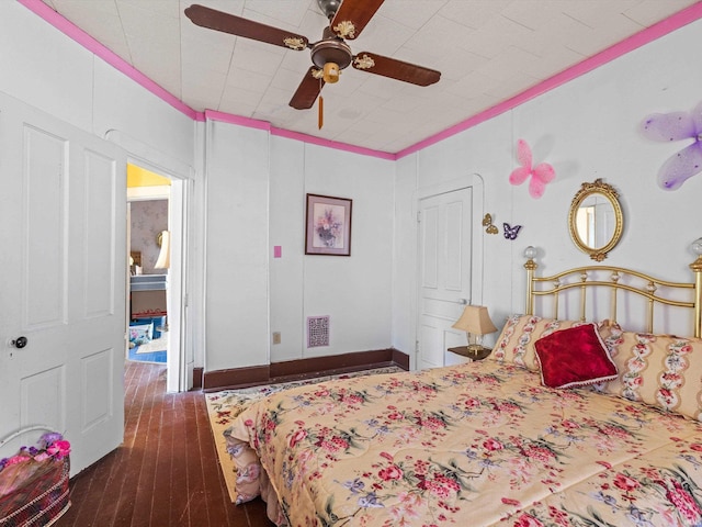 bedroom featuring a ceiling fan, visible vents, dark wood finished floors, and baseboards