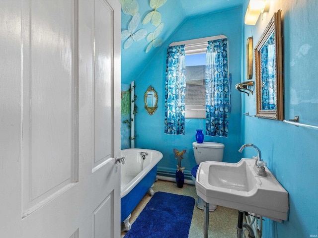 bathroom featuring lofted ceiling, a sink, toilet, and a freestanding bath