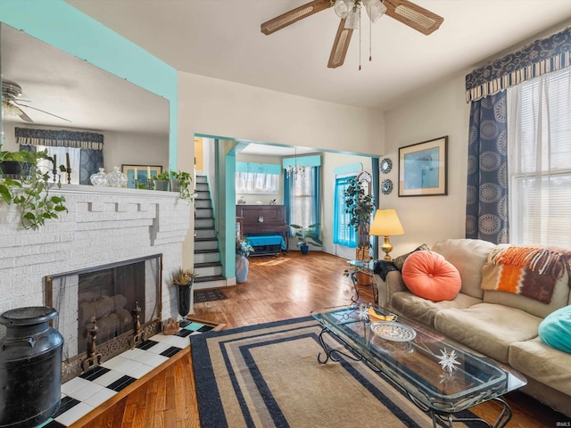 living room with a brick fireplace, ceiling fan, and hardwood / wood-style flooring