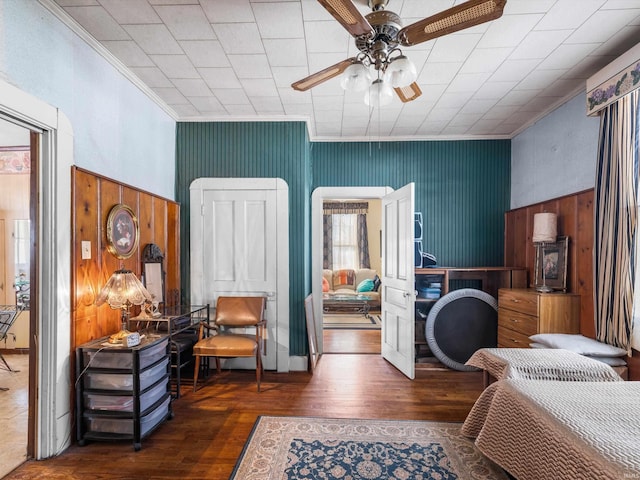 bedroom featuring ceiling fan, ornamental molding, and dark wood-style flooring