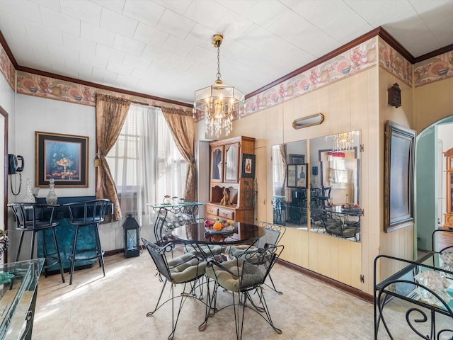 dining space with ornamental molding and an inviting chandelier