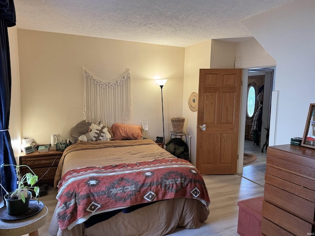 bedroom featuring a textured ceiling and light wood-style flooring