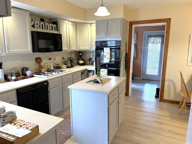 kitchen featuring open shelves, light wood-style floors, light countertops, black appliances, and tasteful backsplash