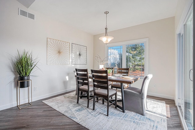 dining area featuring baseboards, visible vents, and dark wood-style flooring