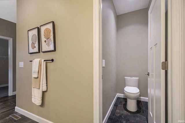 bathroom featuring toilet and baseboards