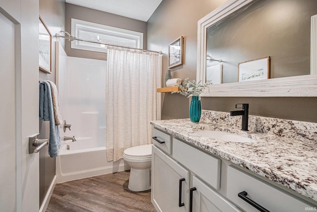 bathroom featuring toilet, shower / bath combo with shower curtain, wood finished floors, and vanity