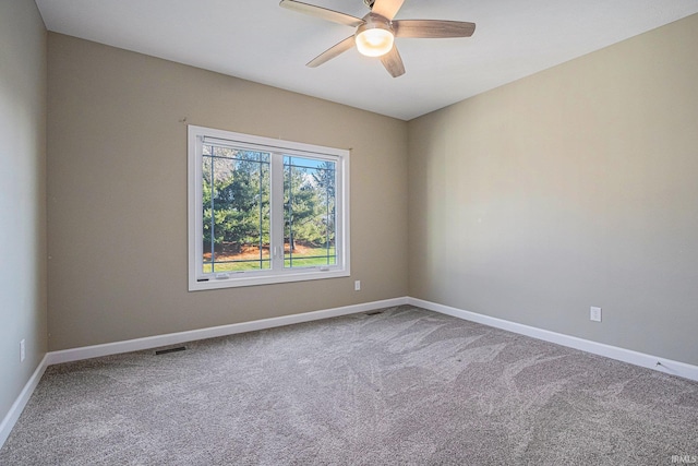 spare room featuring carpet floors, visible vents, and baseboards