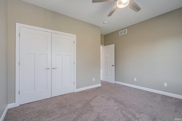 unfurnished bedroom featuring carpet, a closet, visible vents, and baseboards