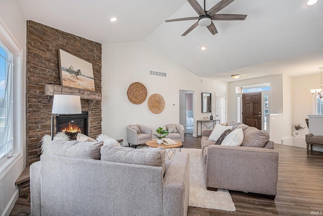 living room featuring a large fireplace, visible vents, dark wood-type flooring, ceiling fan with notable chandelier, and recessed lighting