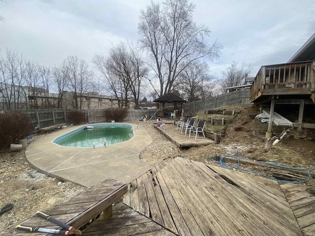 view of swimming pool with a gazebo, a fenced in pool, a fenced backyard, and a wooden deck