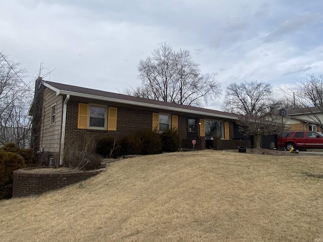 ranch-style house featuring brick siding, an attached garage, and a front lawn