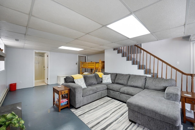 living area featuring stairs, visible vents, a drop ceiling, and finished concrete flooring