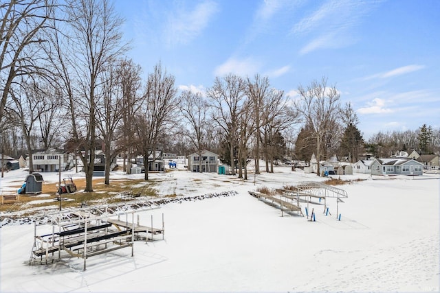 snowy yard with a dock and a residential view