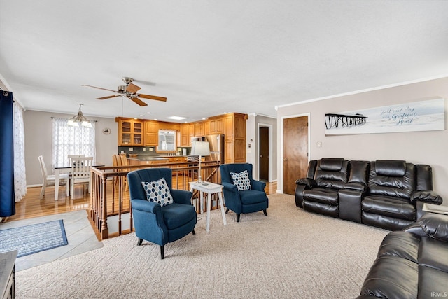 living area featuring ornamental molding, a ceiling fan, and baseboards