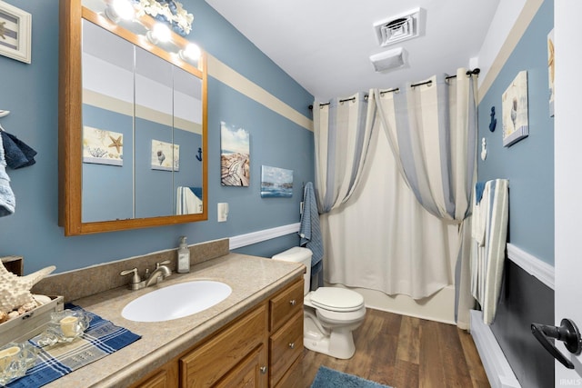 bathroom with toilet, wood finished floors, visible vents, vanity, and shower / bath combo