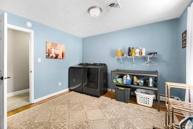 laundry room featuring laundry area, wood finished floors, visible vents, baseboards, and washer and clothes dryer