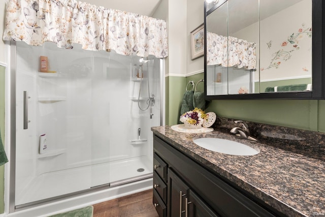 full bath featuring a shower stall, vanity, and wood finished floors