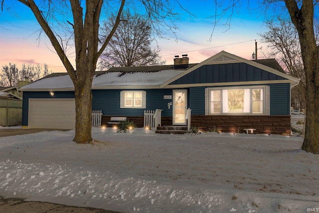 view of front of property with a garage, stone siding, a chimney, and board and batten siding