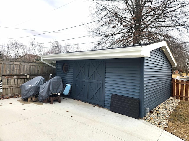 view of outbuilding featuring fence and an outdoor structure