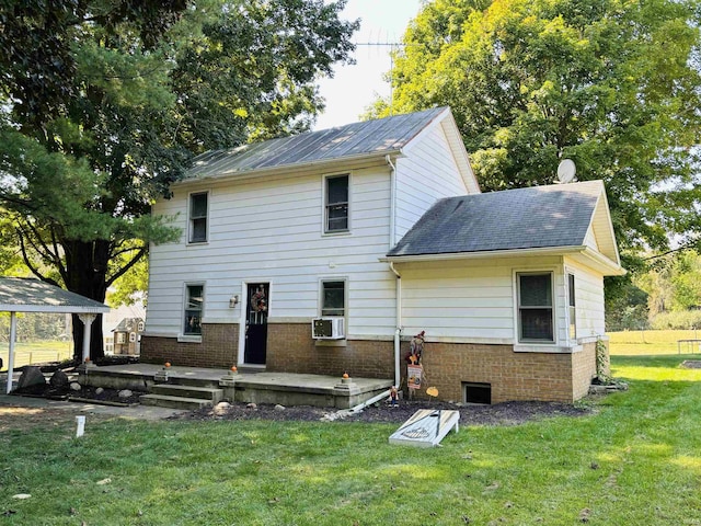 back of house featuring cooling unit, a patio area, a lawn, and brick siding