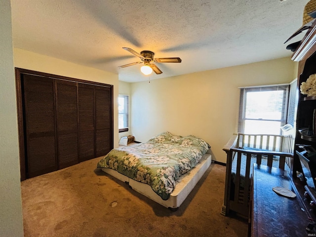 bedroom featuring a textured ceiling, a ceiling fan, a closet, and carpet flooring