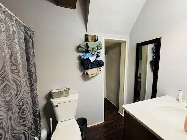 full bath featuring baseboards, toilet, wood finished floors, vaulted ceiling, and vanity