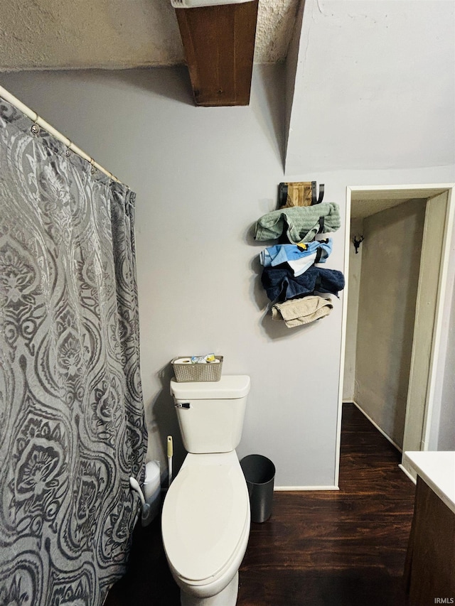 bathroom with toilet, a shower with curtain, baseboards, and wood finished floors