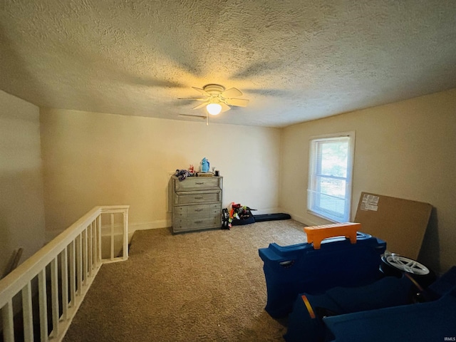 carpeted bedroom featuring ceiling fan, a textured ceiling, and baseboards