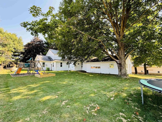 view of yard featuring a trampoline and a playground