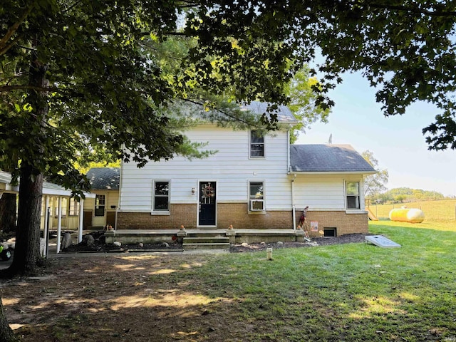 back of house with brick siding and a lawn