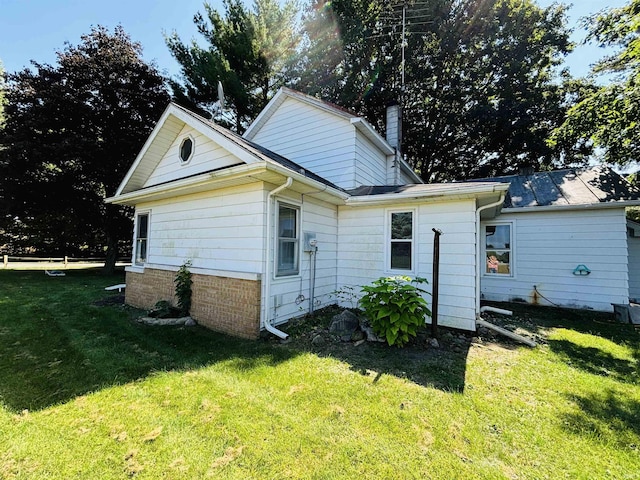 rear view of house with a lawn and a chimney