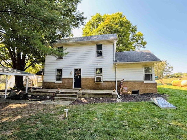 back of property featuring a lawn and brick siding