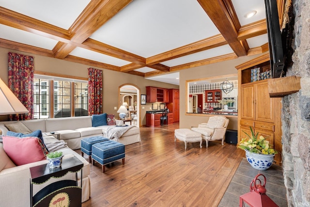 living area with beamed ceiling, coffered ceiling, and wood finished floors