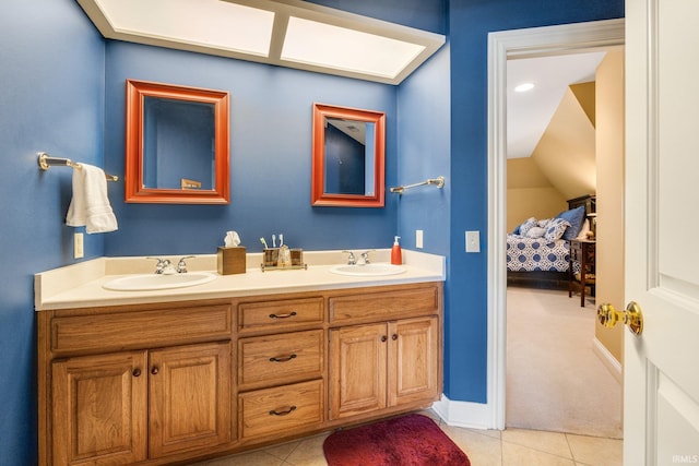 bathroom featuring double vanity, tile patterned flooring, a sink, and ensuite bathroom