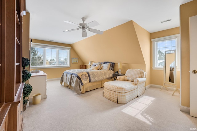 bedroom featuring light colored carpet, vaulted ceiling, baseboards, and ceiling fan