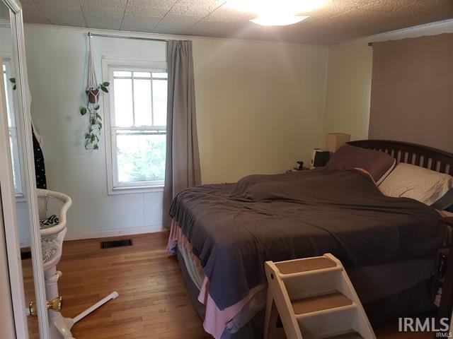 bedroom featuring visible vents and wood finished floors