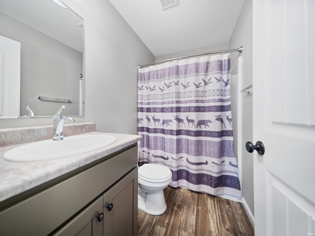 full bath with curtained shower, visible vents, toilet, vanity, and wood finished floors