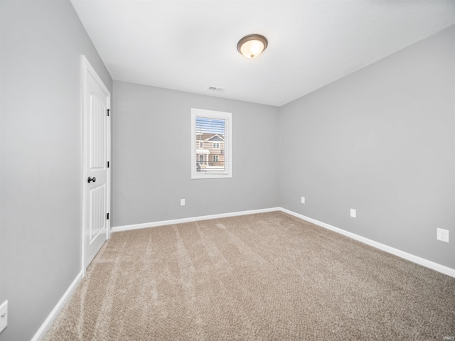 unfurnished room featuring carpet, visible vents, and baseboards