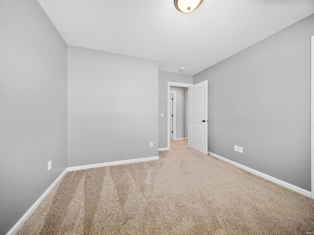 carpeted spare room with baseboards