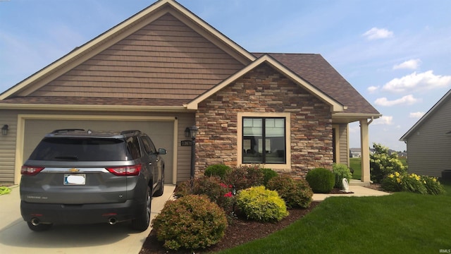 view of front of home featuring an attached garage, stone siding, and roof with shingles