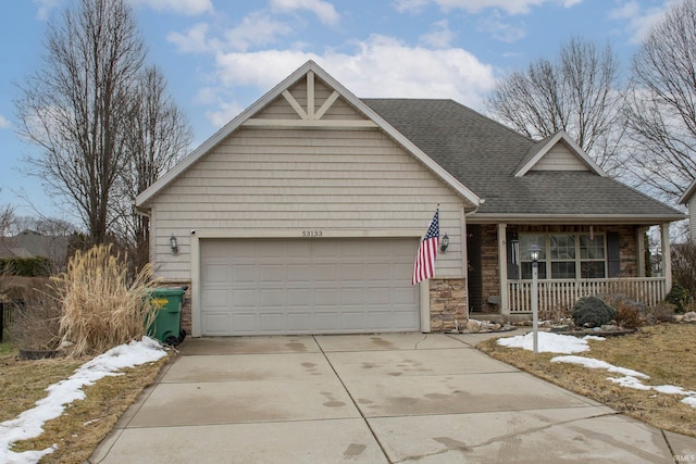 view of front facade featuring a shingled roof, concrete driveway, stone siding, an attached garage, and a porch