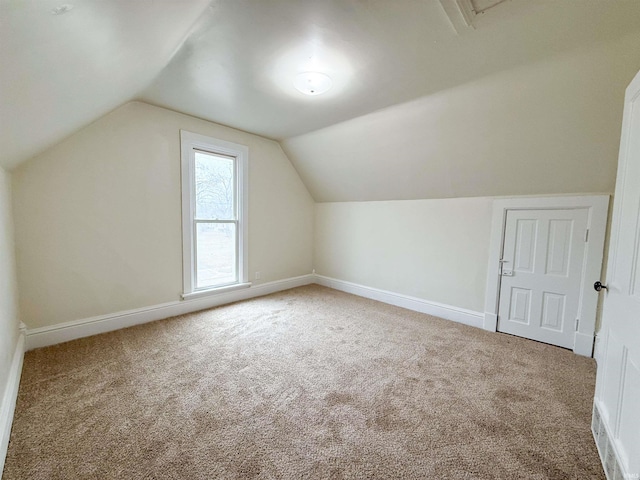 bonus room featuring carpet floors, baseboards, and vaulted ceiling