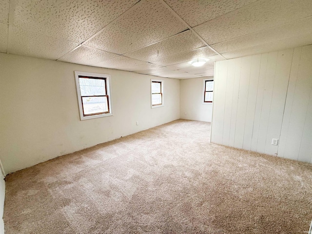 carpeted empty room with a paneled ceiling