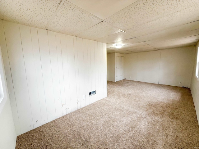 spare room featuring carpet flooring and a drop ceiling